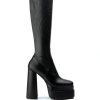 black platform heeled knee high boots with a block heel and 4 way stretch material