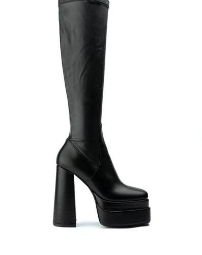 black platform heeled knee high boots with a block heel and 4 way stretch material